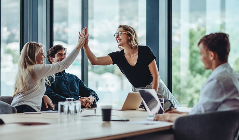 People-sitting-at-table-high-five